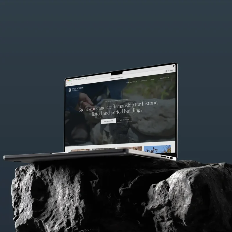 Callaghan Stoneworks, stonemasonry website displayed on MacBook on a dark stone